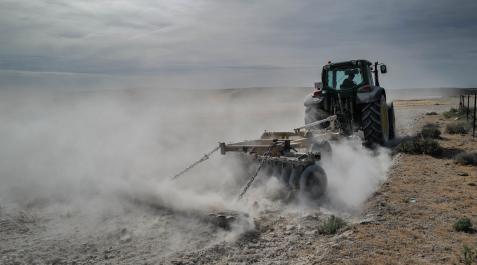 sequia Un tractor ara la tierra seca en un campo de Belchite