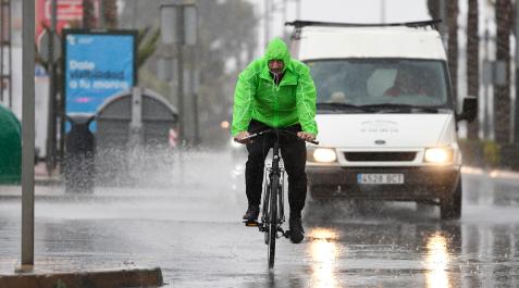 lluvias Un hombre en bicicleta se resguarda con un chubasquero bajo la lluvia en el municipio almeriense de Aguadulce
