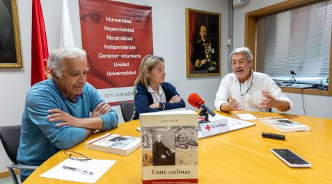 Los estudiosos Guillermo Sánchez (izda) y Jon Arrizabalaga, con la presidenta de Cruz Roja Navarra, Isabel Cadena, en la presentación del libro 'Entre carlistas'..