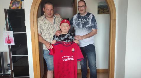 sunbilla Con la camiseta de Osasuna adquirida en la puja del año pasado, Ohian Bazterrika, de 11 años, en etapa revisión de un cáncer padecido, junto a su padre, Aitor, y uno de los promotores del Día de la Salud, de Sunbilla, Aitor Ibarra.
