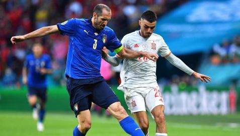 El veterano capitán italiano Giorgio Chiellini, pugna por el balón con Pedri
