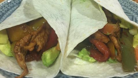 Un plato de fajitas de pollo con verduras