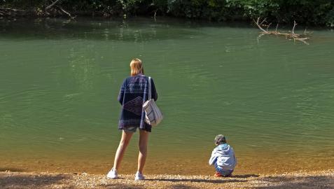 Una mujer y un niño, disfrutando del buen tiempo junto al río en Los Llanos de Estella