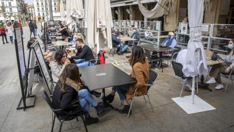 Varios grupos de personas, en terrazas de la Plaza del Castillo de Pamplona