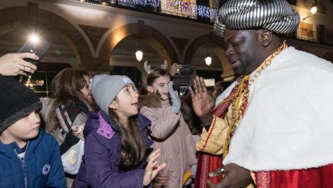 El Rey Baltasar saluda a un grupo de niños y niñas durante la última cabalgata, la de 2020