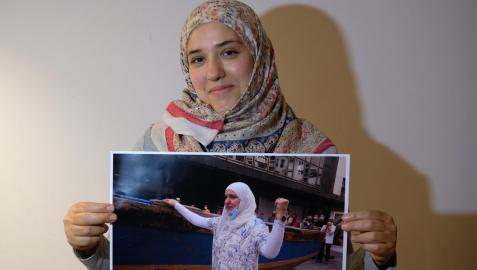 Hadel Arab muestra la fotografía de ella con el puño en alto en la inauguración de la exposición ‘Personas refugiadas: huir para vivir’, imagen que se publicó en este periódico.