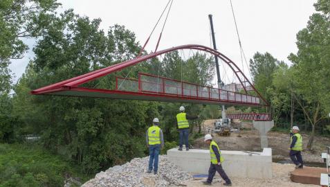 Varios operarios supervisan la colocación de la nueva pasarela del Parque Fluvial del Arga en Landaben. Varios operarios supervisan la colocación de la nueva pasarela del Parque Fluvial del Arga en Landaben.