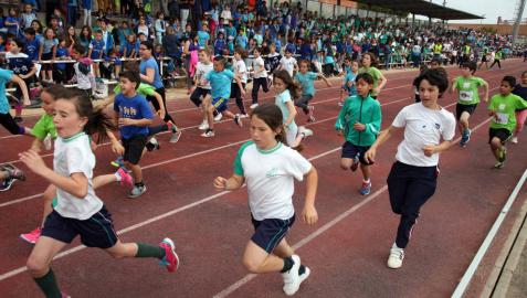 Un grupo de escolares corre sobre la pista del estadio Nelson Mandela ante la mirada de sus compañeros de colegio ubicados en la grada.