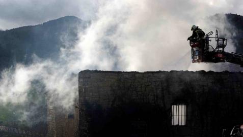 Bomberos del Gobierno de Navarra y agentes de la Policía Foral trabajan en el incendio que esta madrugada ha calcinado una vivienda en la localidad de Artaiz (Unciti).