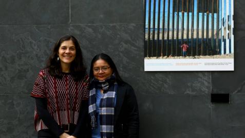 Andrea Villaseñor y Karla Rivas, con una fotografía del periodista Iván Benítez tomada en la valla de Tijuana y que se expone en el Parlamento de Navarra como parte de la muestra 'Stand by: más allá de las fronteras'.