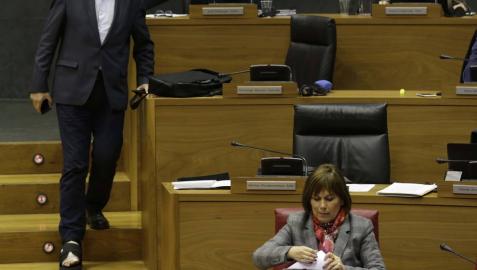 Martínez (Geroa Bai) baja las escaleras del hemiciclo entre Araiz (Bildu) y la presidenta Barkos.