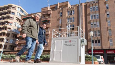 Dos hombres pasan junto a la estación de medición de Tudela.