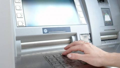 Una persona retira dinero de un cajero automático.