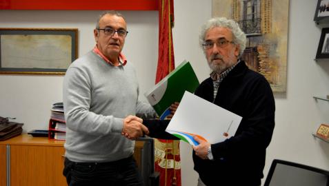 Valentín García (izda.) y Francisco Soto se dan la mano tras haber firmado el convenio.