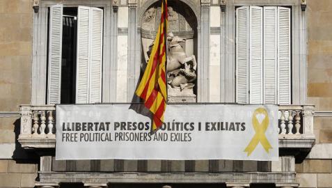 Vista del cartel reclamando la libertad de los líderes independentistas presos y un lazo amarillo en la fachada del Palau de la Generalitat.