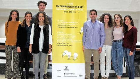 Los alumnos Reyes Hernández, Lucía Prado, María Pérez, Adrián Díaz. Carlos Peña, Lucía Suárez, Celia Canseco y Sara Contreras, en una foto de familia tomada en la Universidad de Navarra junto al cartel que anuncia su logro.