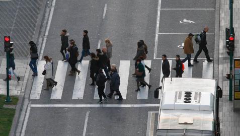 Varias personas cruzan un paso de peatones de Pamplona.