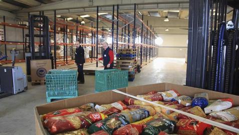 Voluntarios y trabajadores en el Banco de Alimentos organizan los almacenes en los que esperan acumular comida para la gente más necesitada.