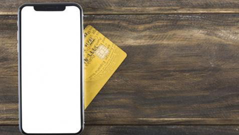 Imagen de un smartphone junto a una tarjeta de crédito
