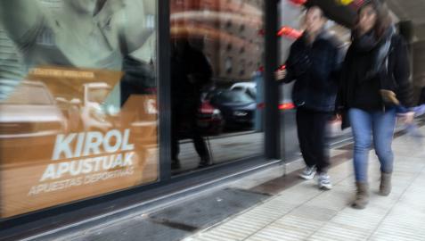 Dos personas pasan delante de una casa de apuestas.