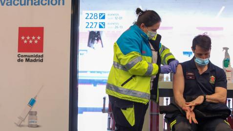 Una sanitaria vacuna a un bombero de la Comunidad de Madrid en el punto de vacunación contra el Covid-19 instalado en el Estadio Wanda Metropolitano