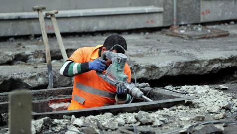 Un trabajador realiza obras en el asfalto de una calle.