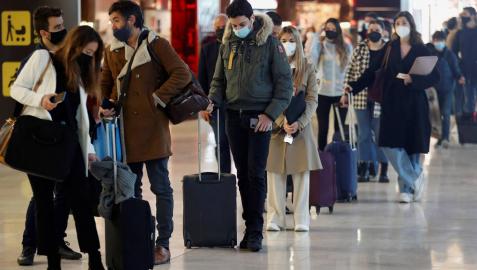 Viajeros hacen cola frente a un mostrador de facturación en el aeropuerto Adolfo Suárez-Barajas de Madrid.