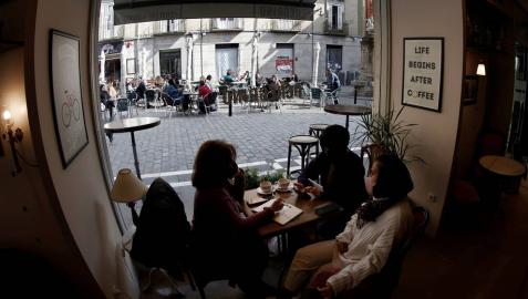 Varios clientes en el interior de una cafetería de Pamplona, con una terraza al fondo. Varios clientes en el interior de una cafetería de Pamplona, con una terraza al fondo.