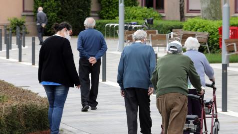 Un grupo de mayores pasea por el exterior de la residencia de la Casa de la Misericordia de Pamplona.