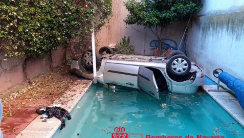 El coche, volcado, tras caer a la piscina.