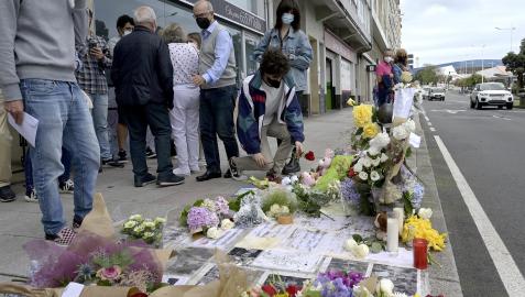 Un joven posa una rosa en el altar colocado en la acera donde fue golpeado Samuel