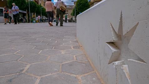 El suelo con adoquines hexagonales y los bancos-jardineras con la estrella de la ciudad en una imagen de la calle San Andrés
