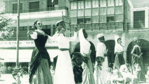 Fotografía de 1954 con los gigantes María Puy y Andrés bailando en la plaza de los Fueros junto al resto de figuras de la comparsa, los reyes moros, Juan de Labrit y Blanca de Navarra.