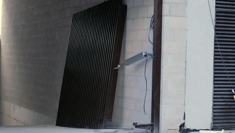 Puerta metálica bajo la que quedó atrapado el trabajador.
