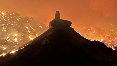 El cerro del castillo de Peñaflor con las llamas del incendio al fondo