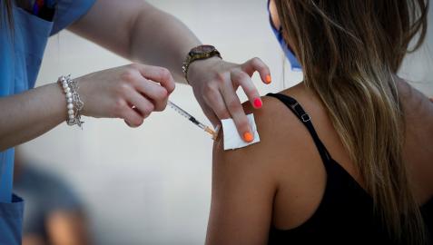 Una sanitaria vacuna a una joven