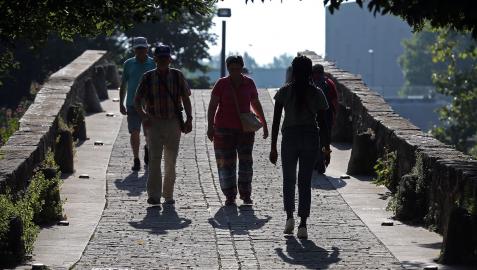 Varias personas pasean por el puente de San Pedro.