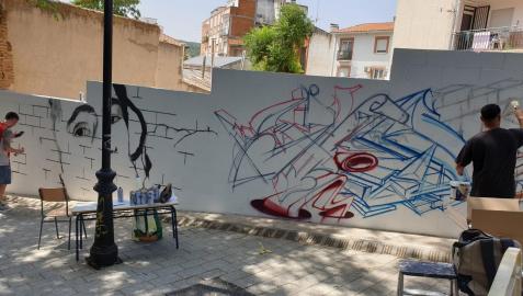 Varios grafiteros decoran una de las fachadas de la localidad madrileña de San Martín de Valdeiglesias.