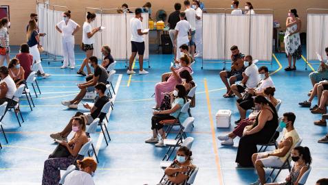 Jóvenes esperan tras ser vacunados en el pabellón municipal de Espartinas (Sevilla)