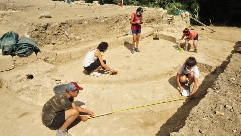Personas voluntarias toman medidas del ábside hallado durante los trabajos de excavación