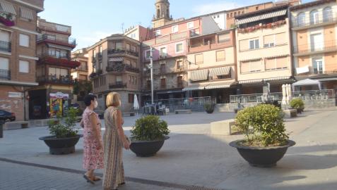 Dos vecinas pasean por la plaza de los Fueros de la localidad Dos vecinas pasean por la plaza de los Fueros de la localidad