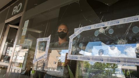 Roberto Lechado, detrás del escaparate acribillado a golpes de su estudio fotográfico en Zizur. Roberto Lechado, detrás del escaparate acribillado a golpes de su estudio fotográfico en Zizur.