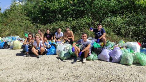 Los ocho jóvenes zizurtarras posan satisfechos con tras dejar despejado el tramo del Camino de Santiago entre Zizur y Galar.