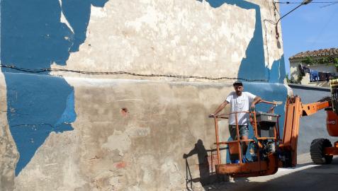 El pamplonés Gabriel Coca, junto al mural que realizó en la calle Rey de Cintruénigo.
