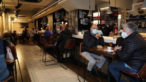 Mesas y sillas altas en el bar Río de Pamplona, como alternativa a la imposibilidad de consumir de pie en la barra