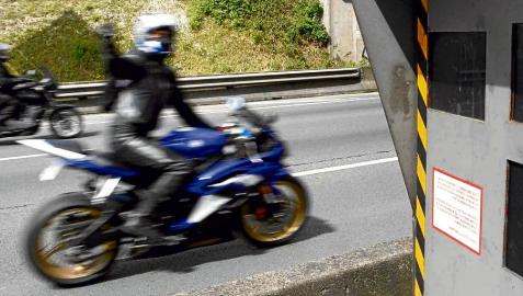 Un motorista realiza un gesto a su paso por un radar, que controla la velocidad de los vehículos