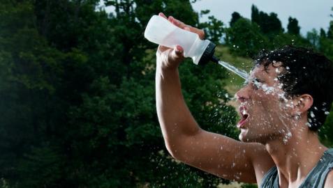 Un deportista, echándose agua