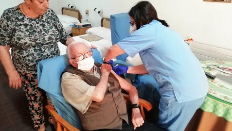 Una sanitaria pone una vacuna a un anciano en una residencia de Andalucía