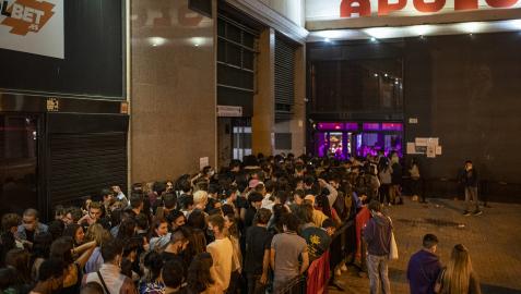 Grupos de jóvenes en las inmediaciones de un local de ocio nocturno la misma noche en que entra en vigor la reapertura en interiores a medianoche en Barcelona