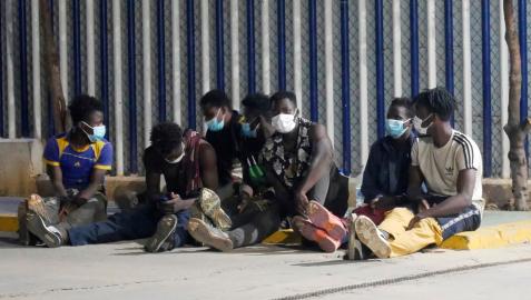 Varios migrantes de origen subsahariano permanecen bajo vigilancia policial tras acceder a Melilla saltando el perímetro fronterizo entre España y Marruecos